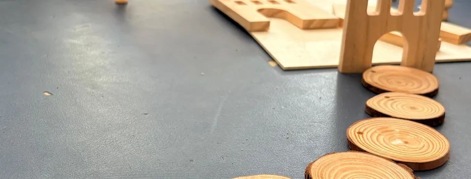 Camino de rodajas de madera y casitas en el suelo del aula de Sandra
